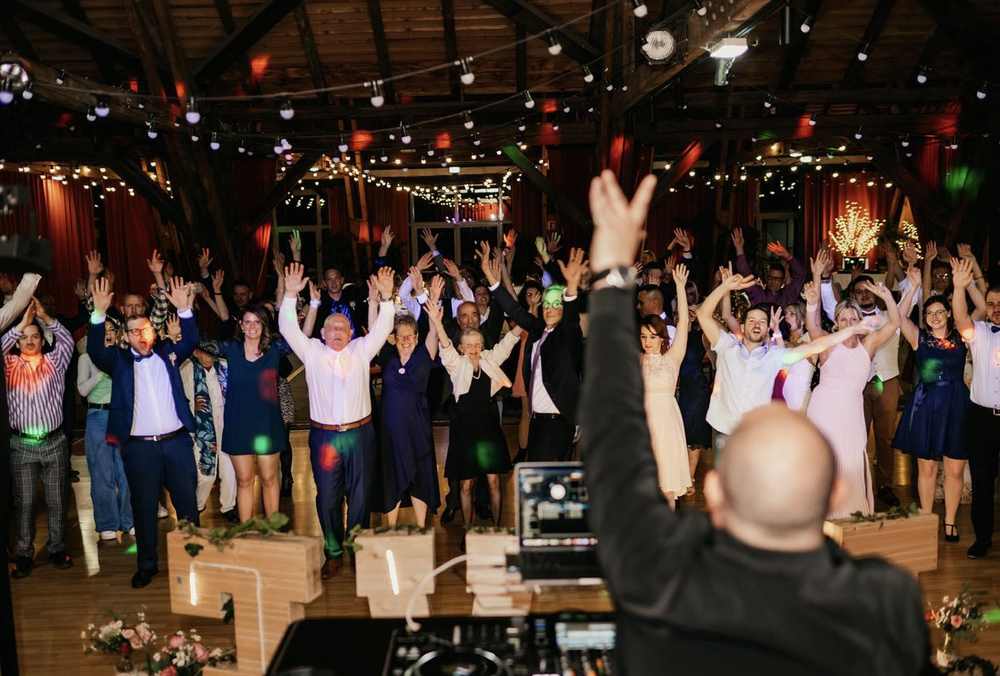 Salle entière bras en l'air face au DJ, sous la charpente de l'Écomusée d'Alsace