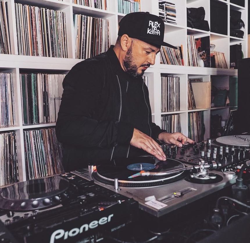 Alexandre Da Costa aux platines dans son studio, devant sa discothèque