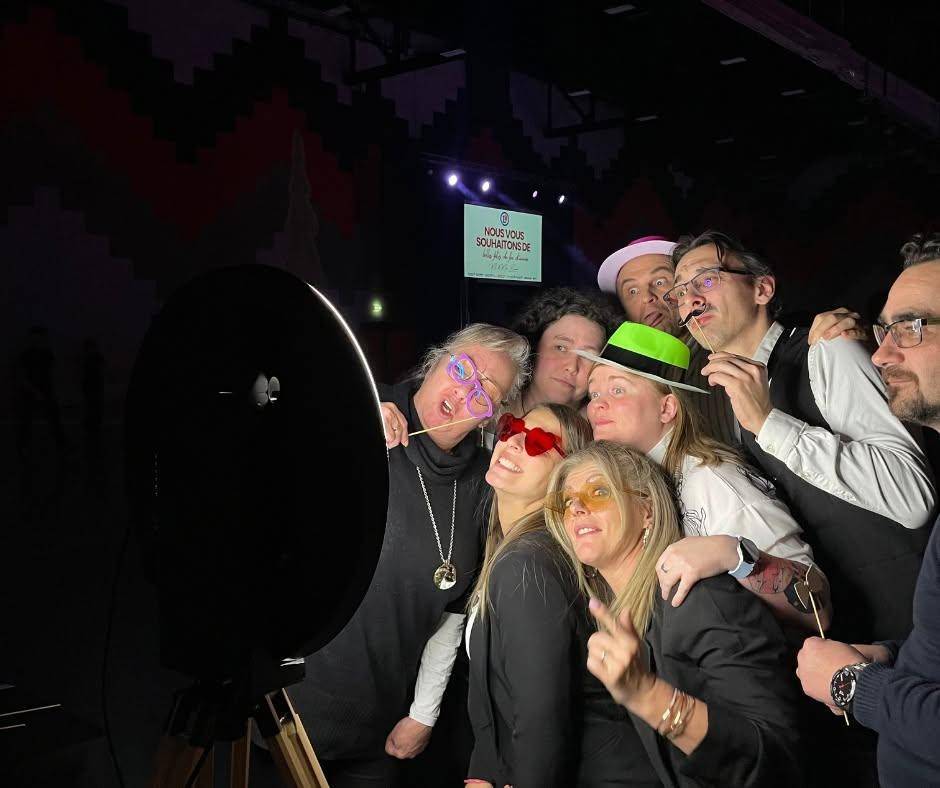 Groupe posant devant la borne photo avec des accessoires
